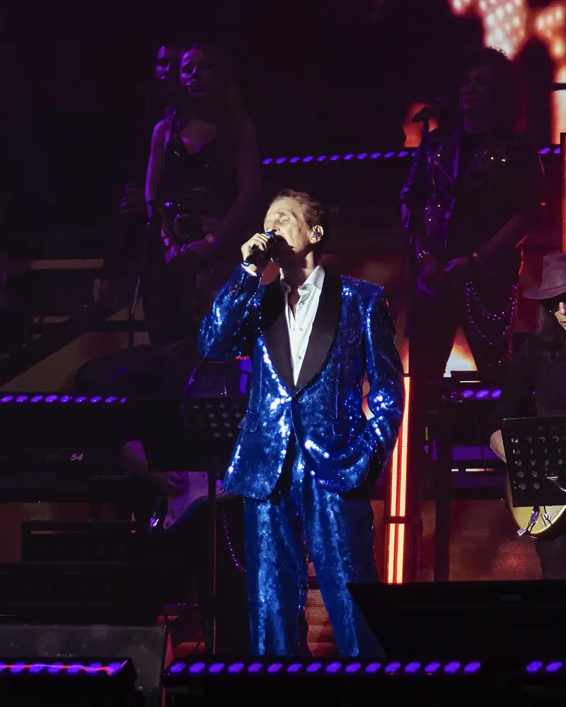Emmanuel cantando en el escenario con su banda