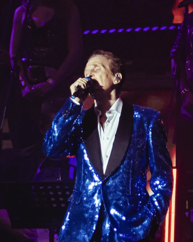 Emmanuel cantando en el escenario con su banda